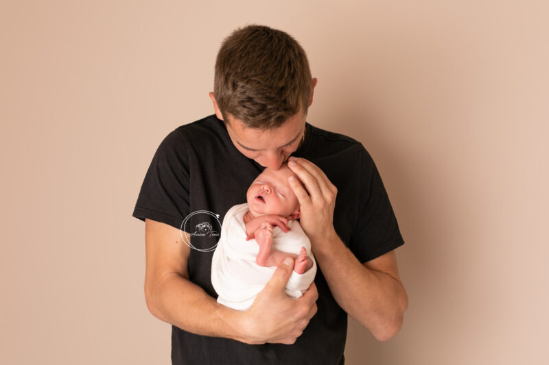 Photo d'un père et sa fille de quelques jours pendant une Séance Nouveau-né Studio Saint-Etienne Loire 42